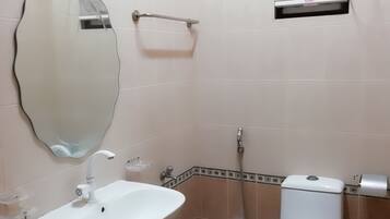 Un baño con lavamanos, inodoro y espejo.