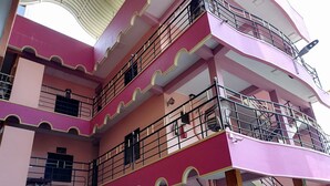 A multi-story building with pink and white exterior walls, balconies with railings, and a staircase. - Sunshine Hotel & Hall (Trincomalee)