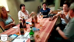 Un grupo de personas sentadas alrededor de una mesa con botellas y vasos, probablemente con bebidas.