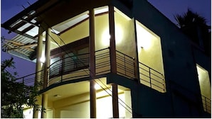 Un edificio de varios pisos con balcones y un espacio exterior techado.