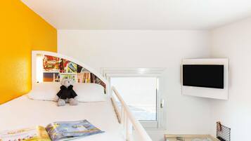 A child's bedroom with a bunk bed, a desk, a chair, a TV, and a bookshelf.