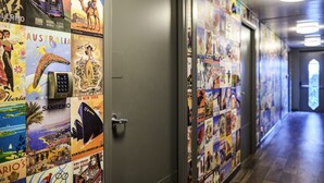 Un couloir orné d’affiches de voyage et une porte équipée d’un lecteur de cartes magnétiques.