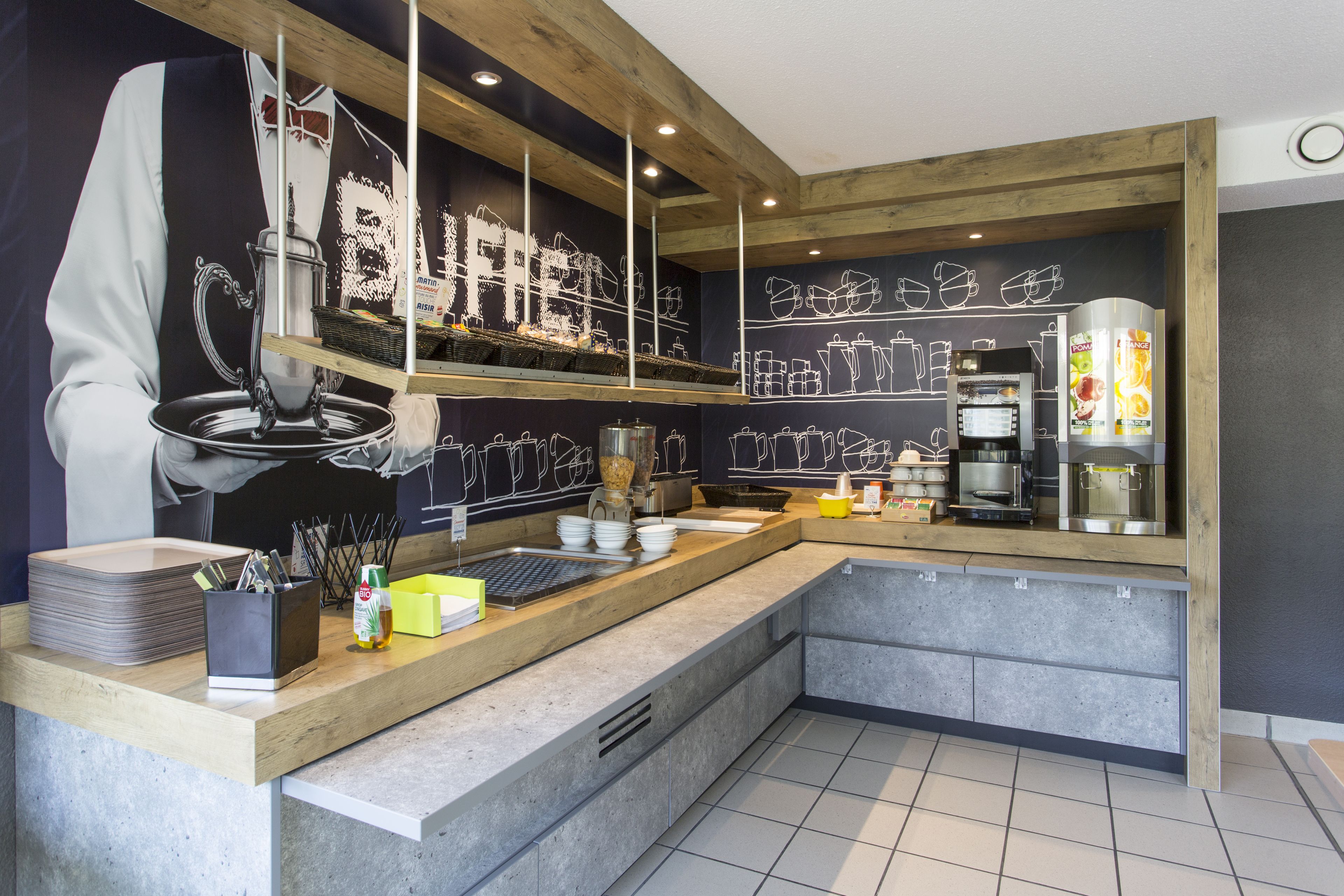 A modern kitchen with a wooden countertop, a coffee machine, and a chalkboard wall with kitchen utensils.
