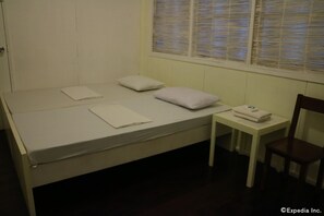 A single bed with pillows and a folded towel on a white table beside it. - Mainstreet Pension House (Bacolod)
