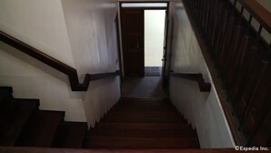 Un escalier en bois, doté d’une rampe et d’une porte en haut.