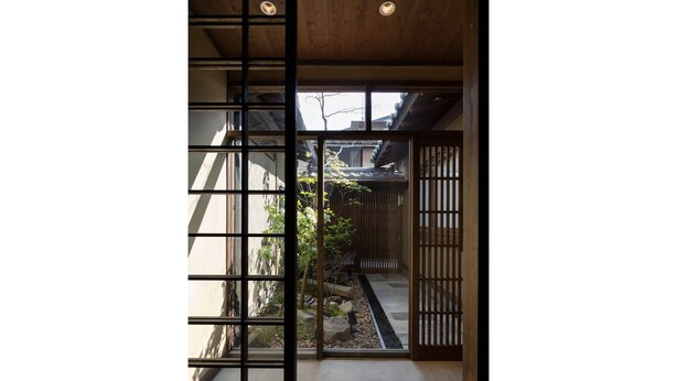 Ein traditionelles japanisches Interieur mit Schiebetüren, die zu einem Garten führen.
