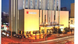A modern hotel building with a prominent entrance and a well-lit facade. - Tian Feng International Hotel (Shenyang)