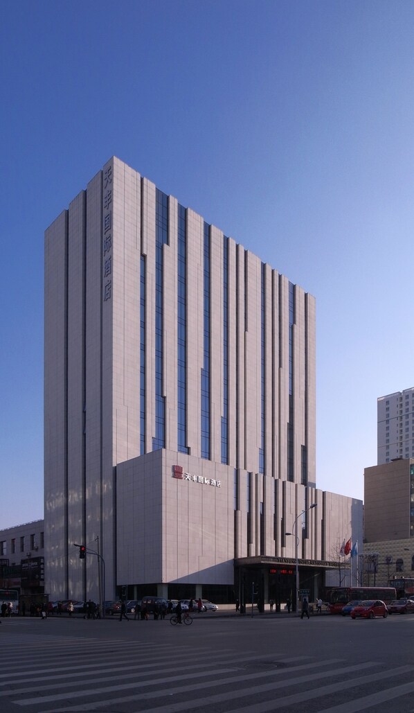 A modern building with vertical lines and a sign indicating it is a hotel.