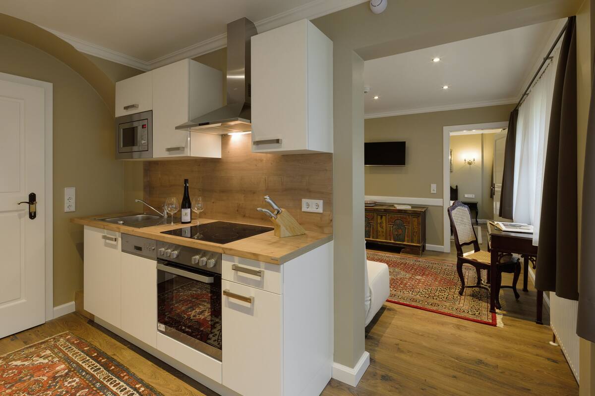 A modern kitchen with a built-in oven, microwave, and stainless steel range hood.