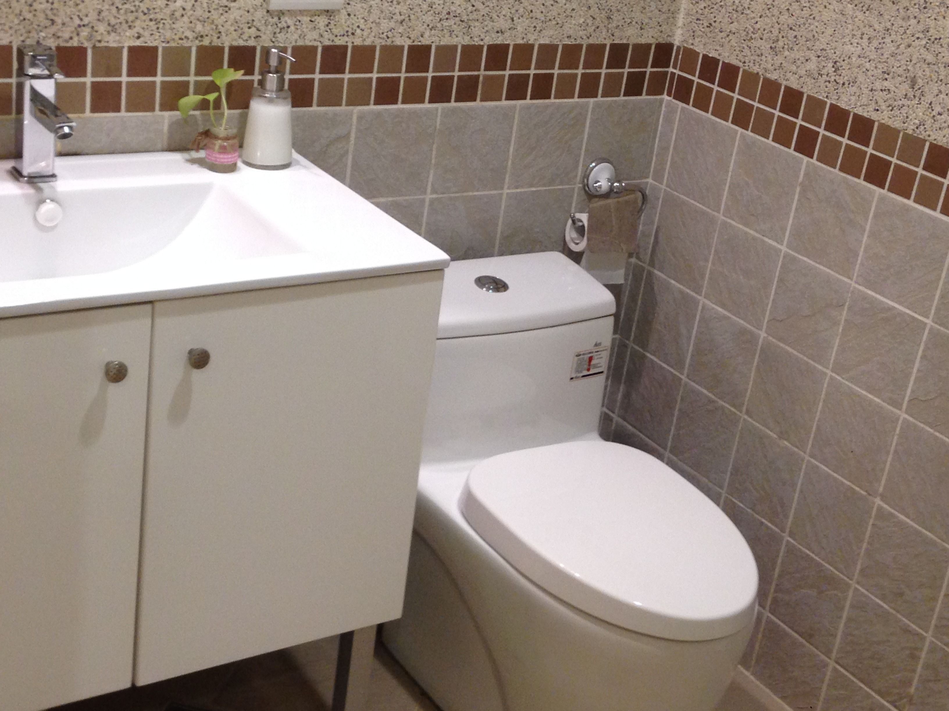 Un baño con un lavamanos blanco, un inodoro y una ducha.