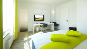 Quarto de hotel moderno com cama, escrivaninha, cadeira, televisão e janela com cortinas.