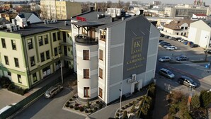 Un hotel con un letrero llamativo, varios pisos y un estacionamiento.