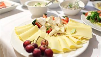 Una mesa con diversos platos, incluyendo un plato de queso y uvas.