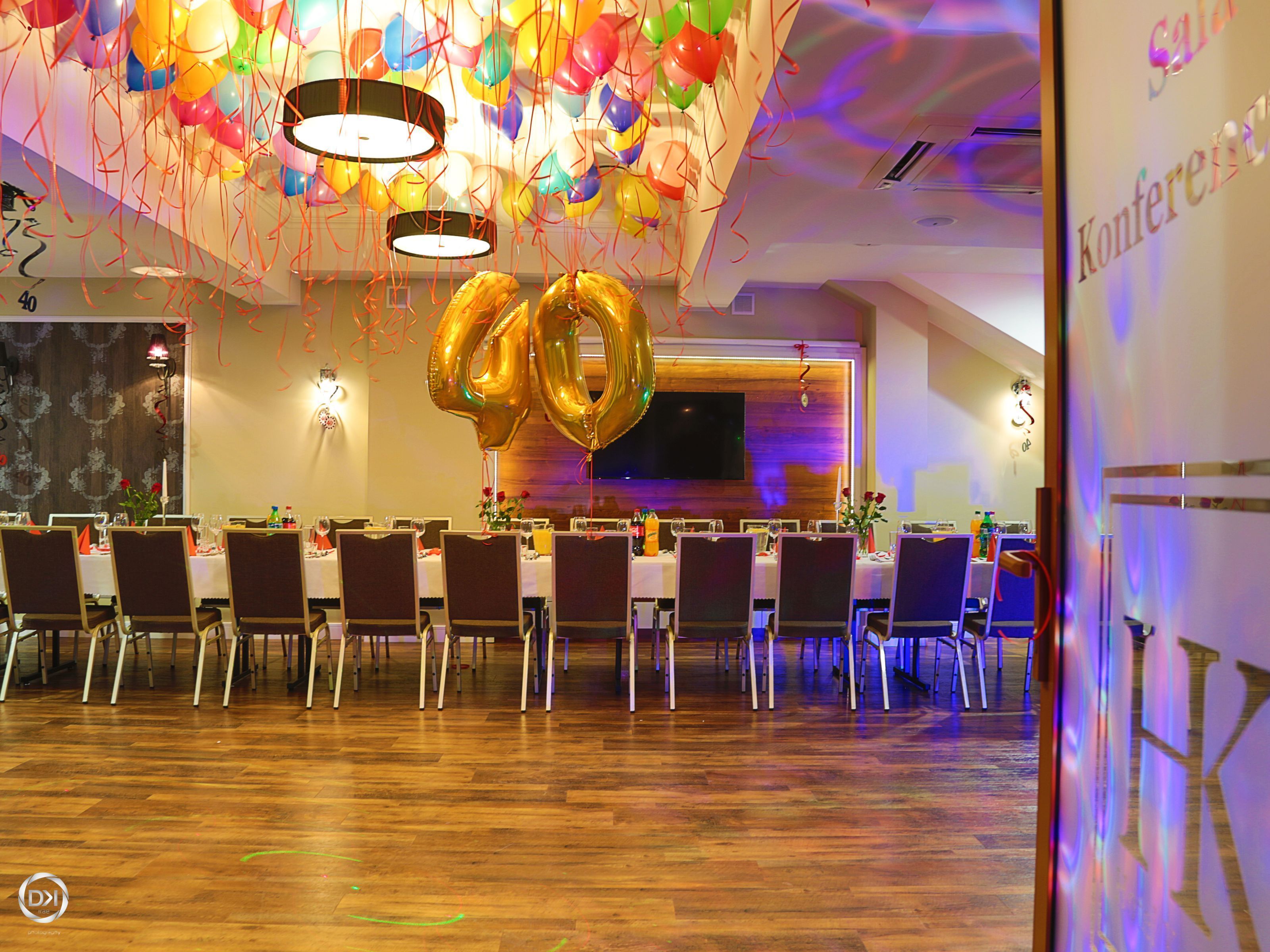 A conference room with a long table, chairs, and balloons.