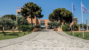 Un camino pavimentado que lleva a un edificio con un letrero que dice "THAI".