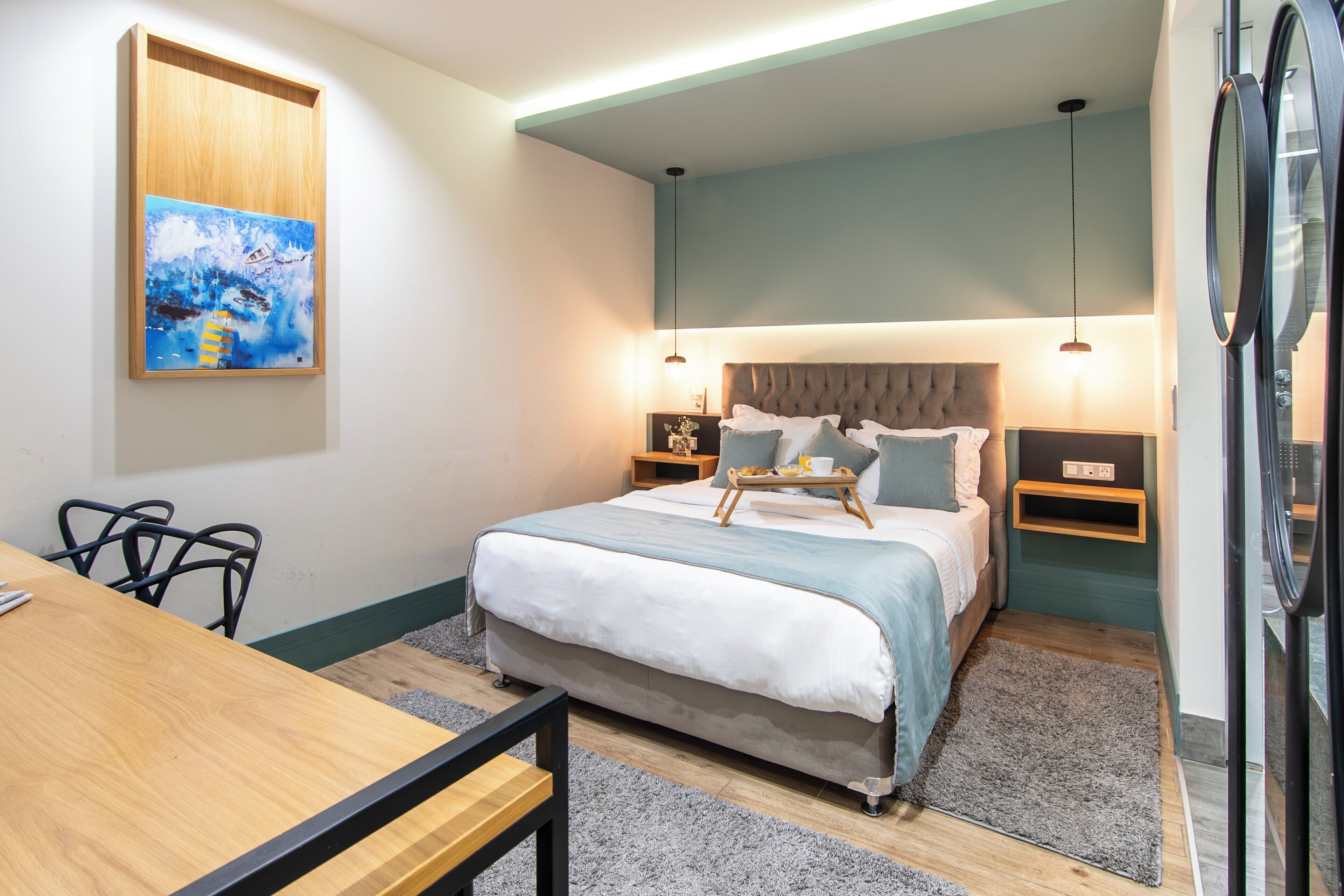 Un dormitorio con cama, mesitas de noche, escritorio y silla.
