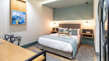 Un dormitorio con cama, mesitas de noche, escritorio y silla.