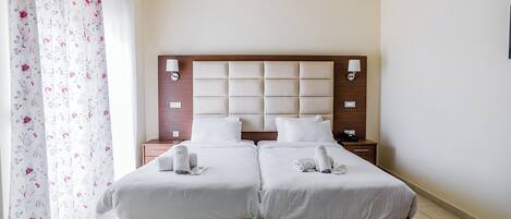 A double bed with a wooden headboard and two bedside tables, each with a lamp.