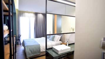 Una habitación de hotel moderna con cama, mesita de noche y un espejo grande.