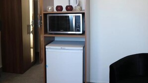 Eine kleine Küchenzeile mit einer Mikrowelle und einem kleinen Kühlschrank.