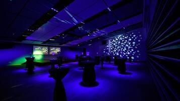 A modern interior with a geometric ceiling design, ambient lighting, and a wall with circular light patterns.
