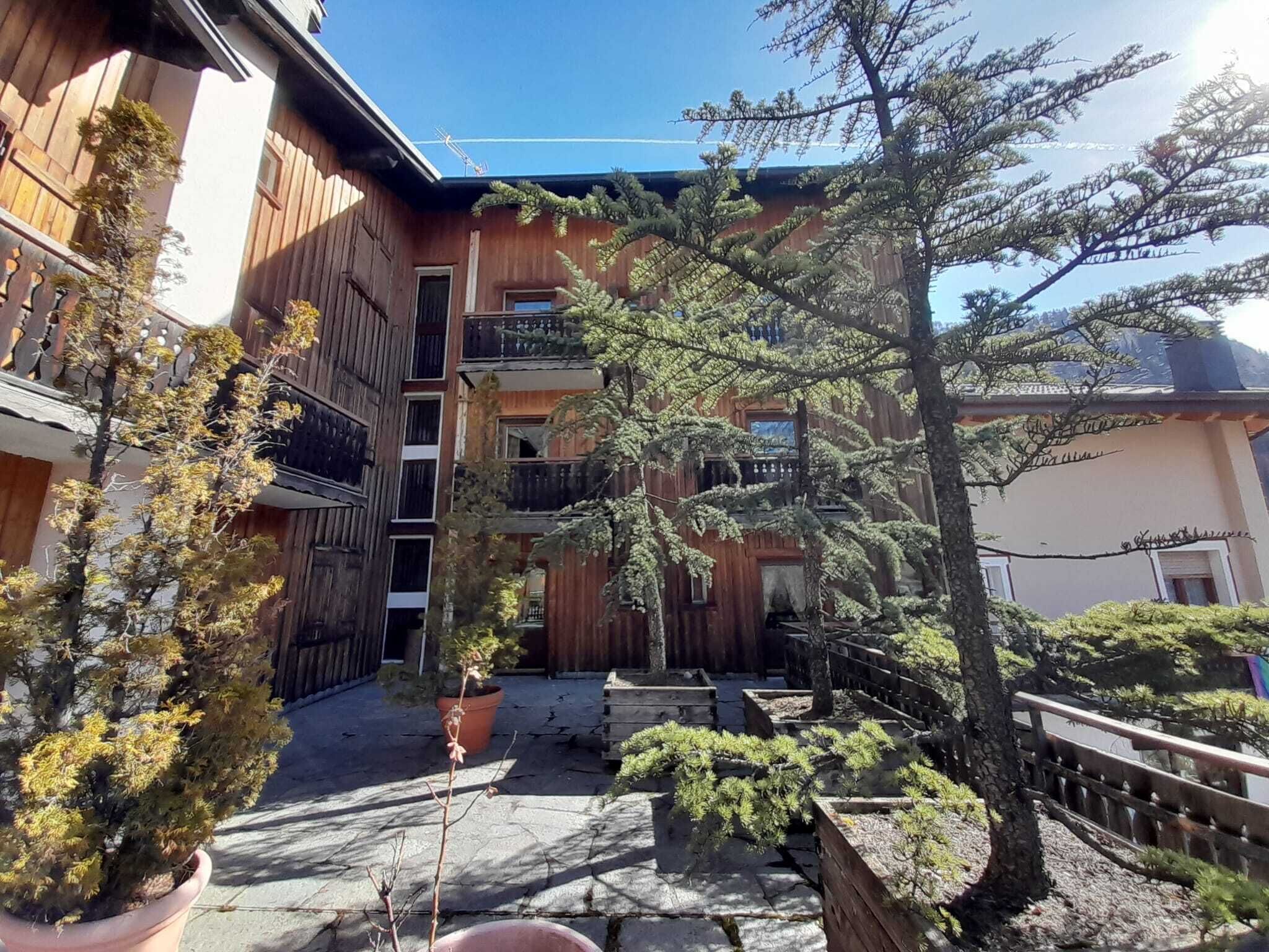 Ein Holzhaus mit Balkon und Blumentöpfen.