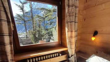 Una habitación con ventana de madera, cortinas, un radiador y una cama.