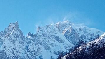 A snow-covered mountain range with sharp peaks and a clear blue sky.