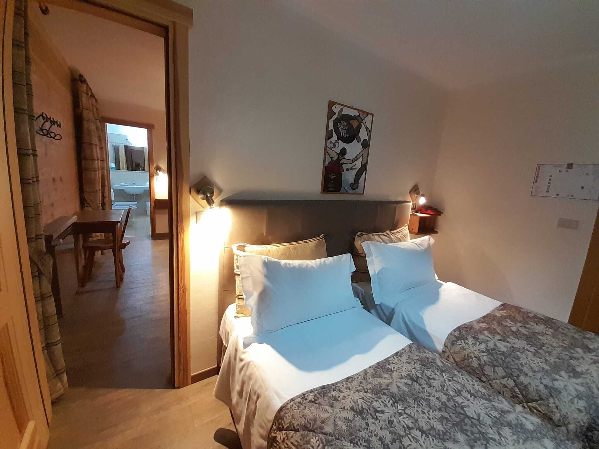Une chambre à coucher avec un lit, des tables de chevet et une œuvre d’art accrochée au mur.