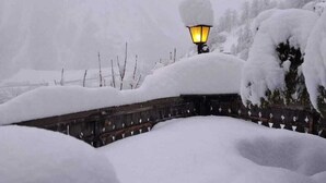 A snow-covered landscape with a lit street lamp and a wooden fence. - Hotel Astoria (Courmayeur)