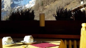 A table set for two with a mountain view in the background. - Hotel Astoria (Courmayeur)