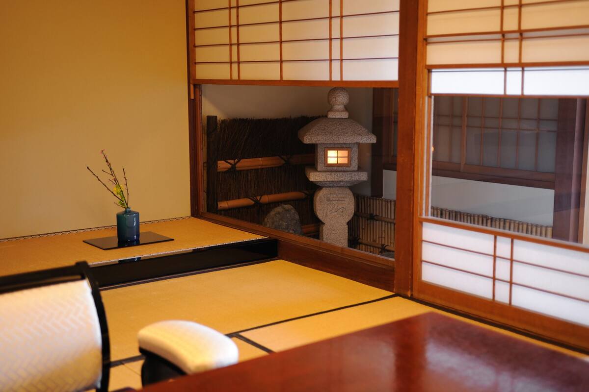 Une pièce de style japonais traditionnel, avec un sol recouvert de tatamis, une table basse et un paravent shoji.