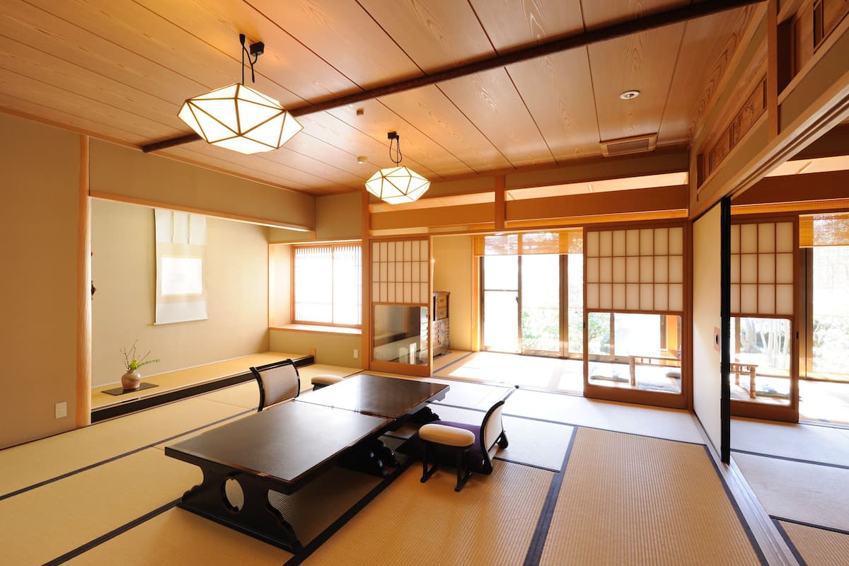 Une pièce de style japonais traditionnel, avec un sol recouvert de tatamis, une table basse et des portes coulissantes.