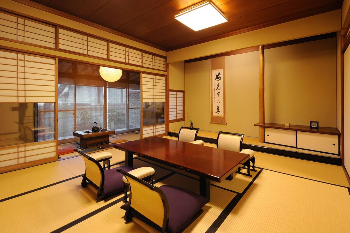 Une pièce de style japonais traditionnel, avec un sol recouvert de tatamis, une table basse et des paravents coulissants.