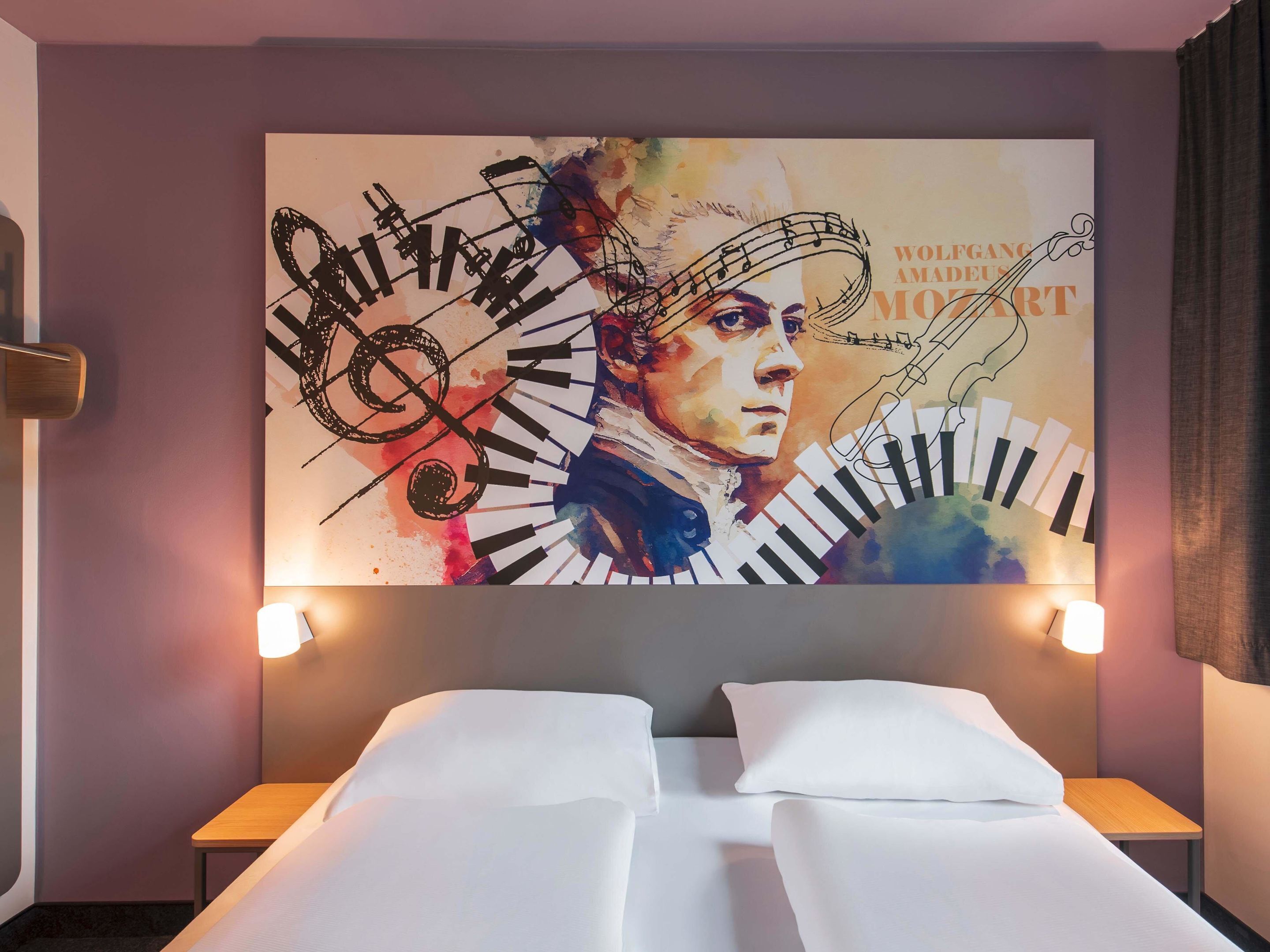 Habitación de hotel con un gran mural en la pared de temática musical, dos camas, mesitas de noche y lámparas de pared.