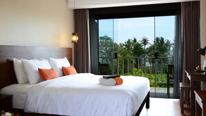 A hotel room with a large bed, a desk, and a balcony with a view of palm trees. - The Edelweiss Ultimo Canggu (Cemagi)