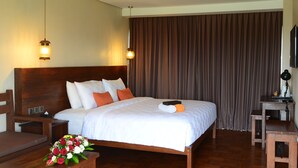A hotel room with a large bed, wooden headboard, two bedside tables, a desk, and a television. - The Edelweiss Ultimo Canggu (Cemagi)