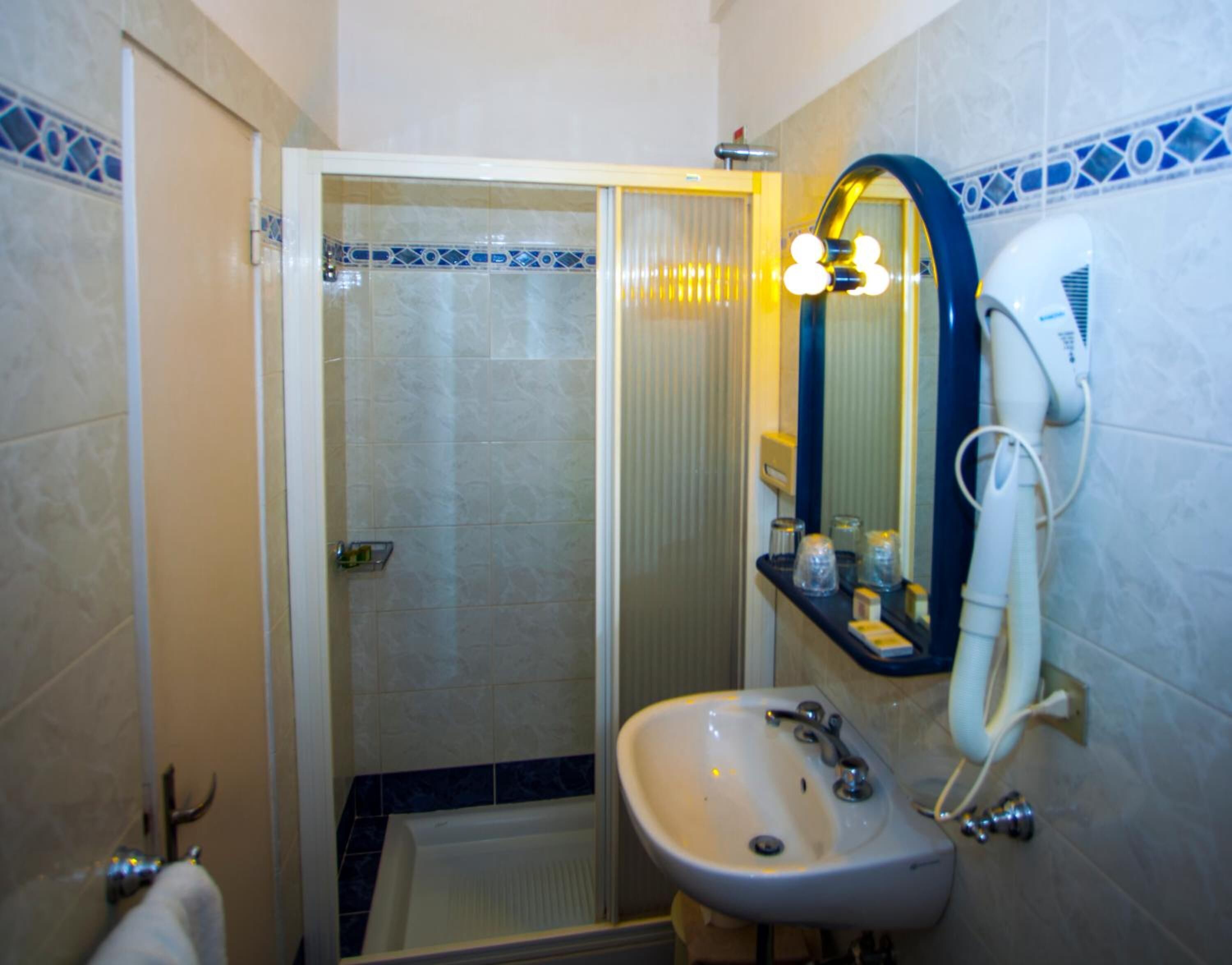 Ein Badezimmer mit Dusche, Waschbecken und Spiegel.