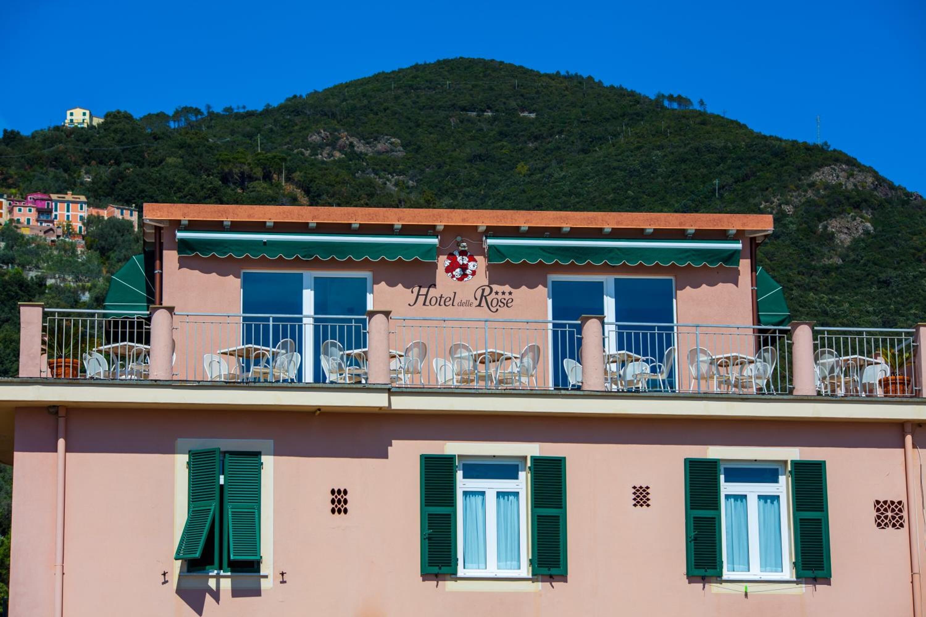 A hotel named "Hotel delle Rose" with a balcony featuring outdoor seating.