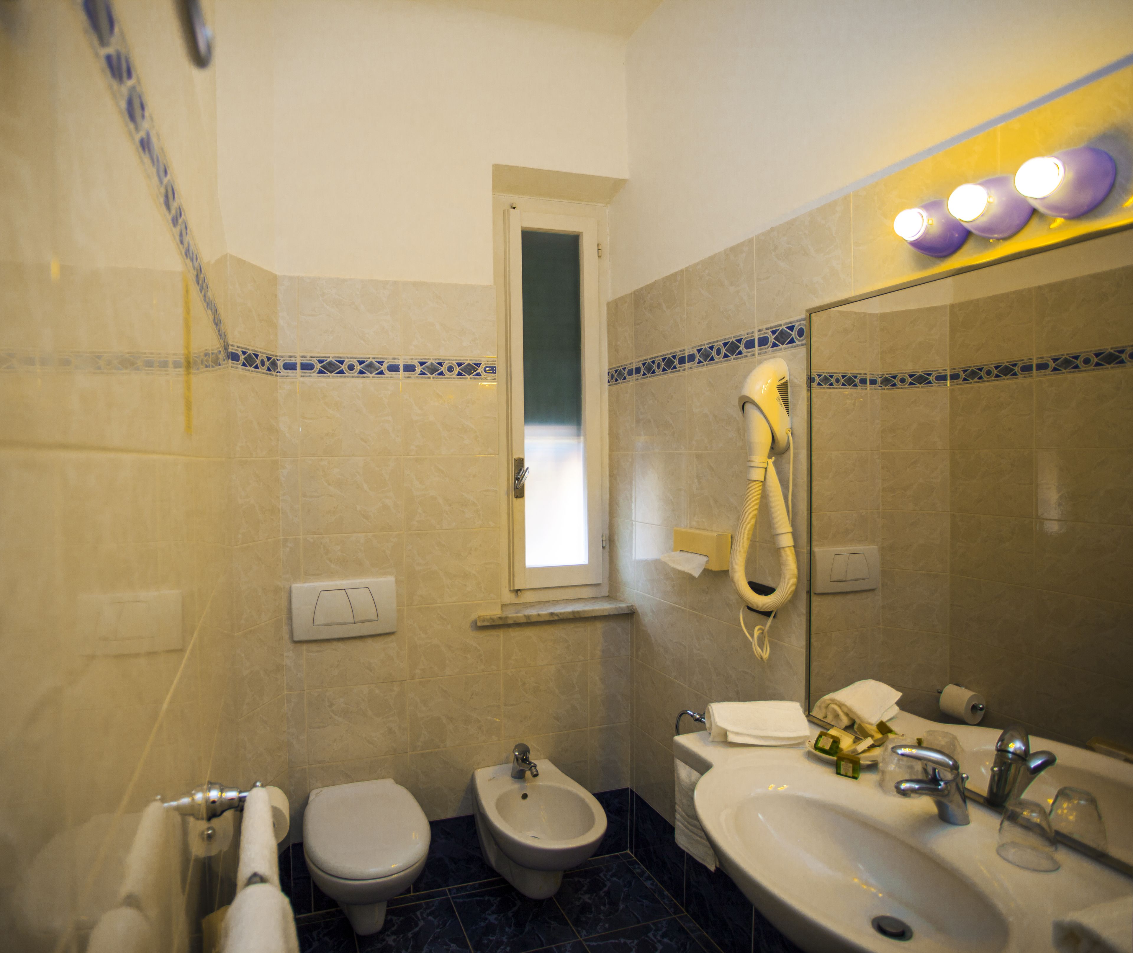 A bathroom with a toilet, bidet, and sink.