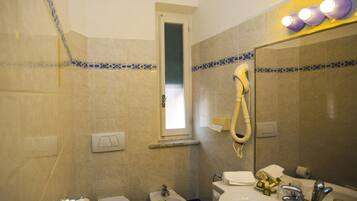 A bathroom with a toilet, bidet, and sink.