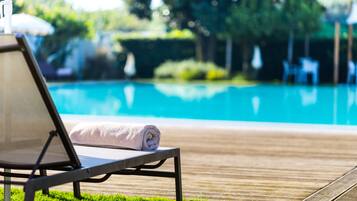 Una piscina al aire libre, tumbonas