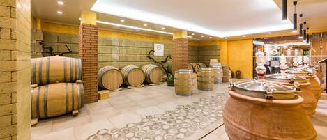 A modern interior with wooden barrels, a patterned rug, and a brick wall.