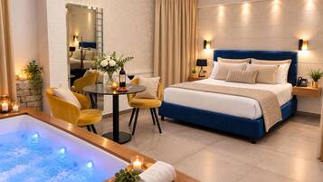 Ein modernes Hotelzimmer mit einem großen Bett, einer Sitzecke mit Tisch und Stühlen, einer Badewanne und einem Spiegel.
