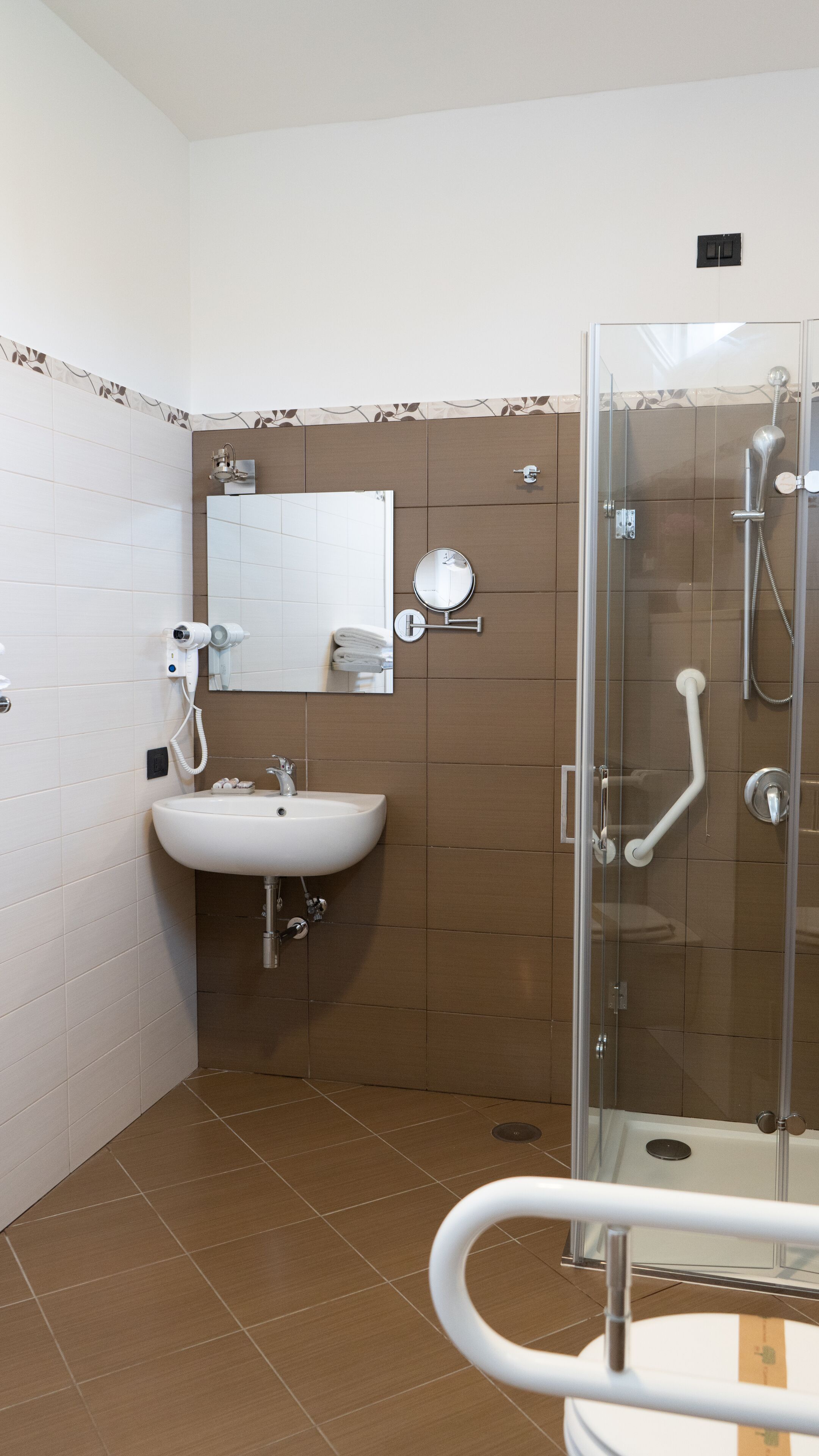 A bathroom with a sink, mirror, and shower.