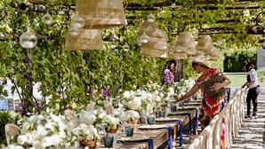 An outdoor dining area with tables set for a meal, surrounded by greenery and hanging light fixtures. - Resort & Winery Bosco De Medici  (Pompei)
