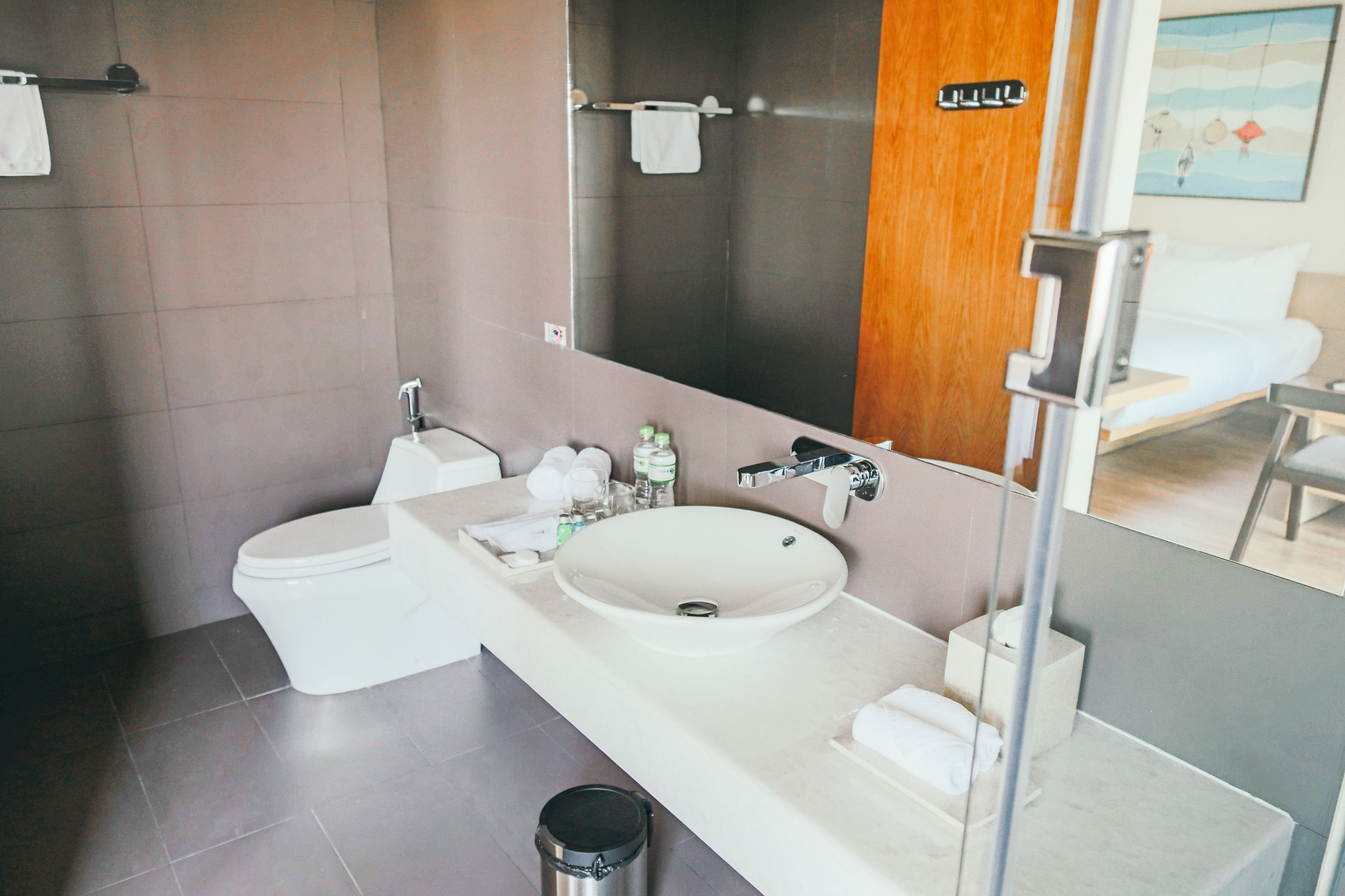 A modern bathroom with a toilet, sink, and mirror.