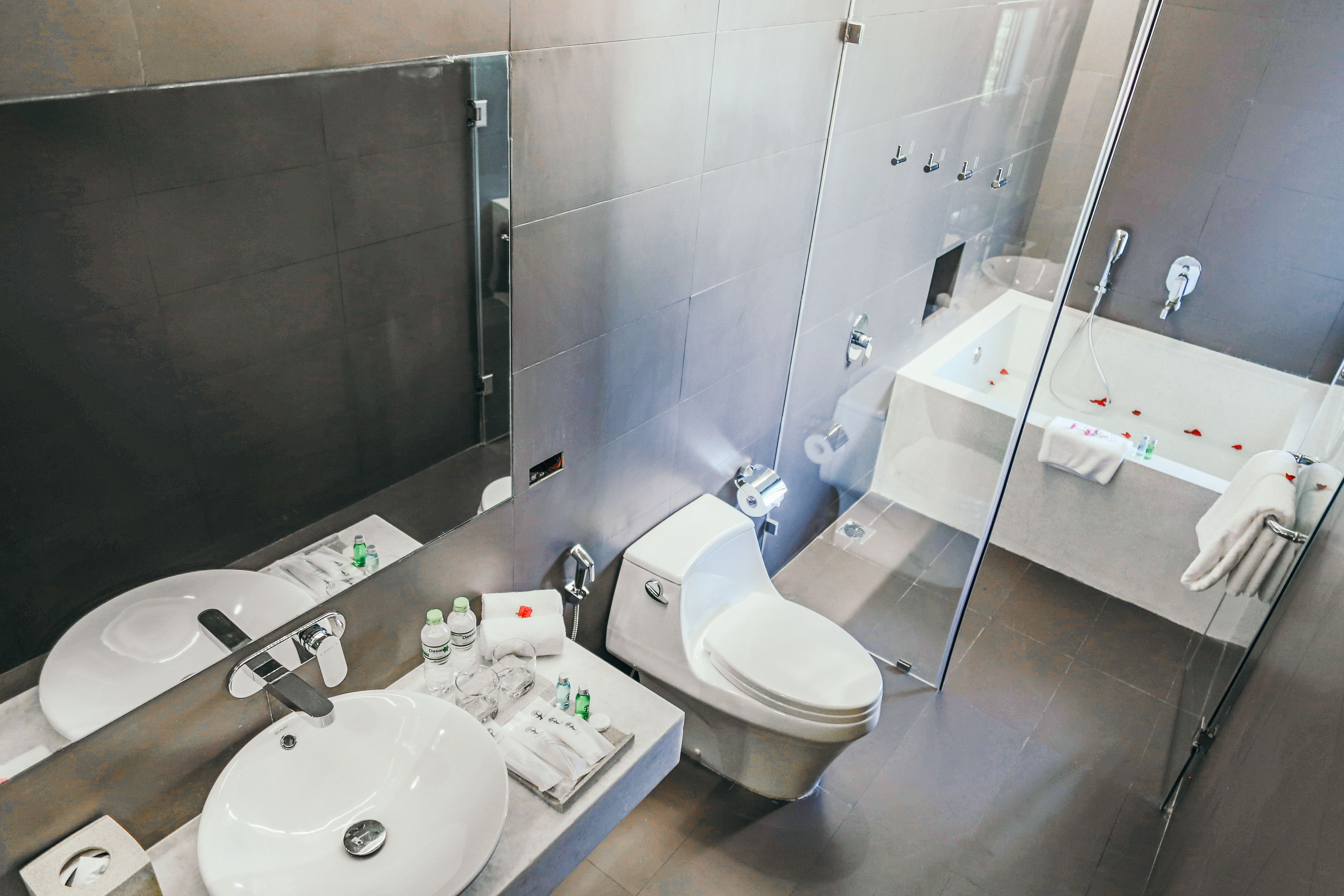 Ein modernes Badezimmer mit zwei Waschbecken, einer Toilette und einer gläsernen Duschkabine.
