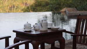 A wooden table with white teacups and a teapot by a lake. - Birds Park Polgahawela (Alawwa)