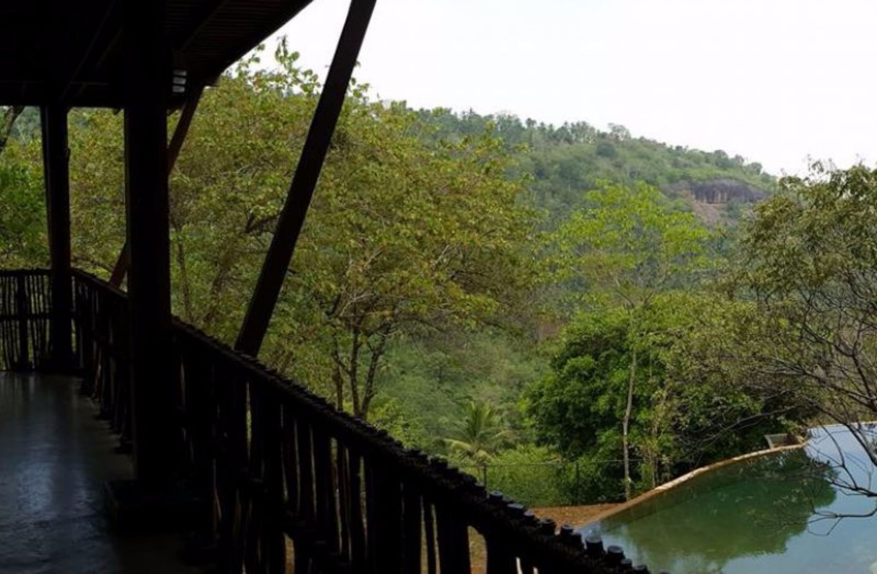 A wooden deck overlooking a lush green landscape with a river.